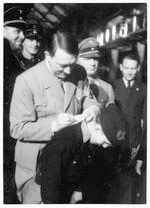 Hitler signing autograph on back of Hitler Youth boy Hitler signing autograph on back of Hitler Youth boy