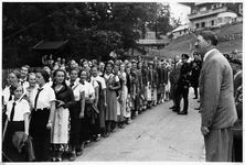 Hitler greeting a line of young women visitors at the Berghof driveway