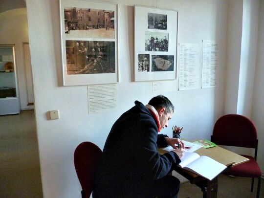 Man signing visitors' book at Colditz Castle Man signing visitors' book at Colditz Castle
